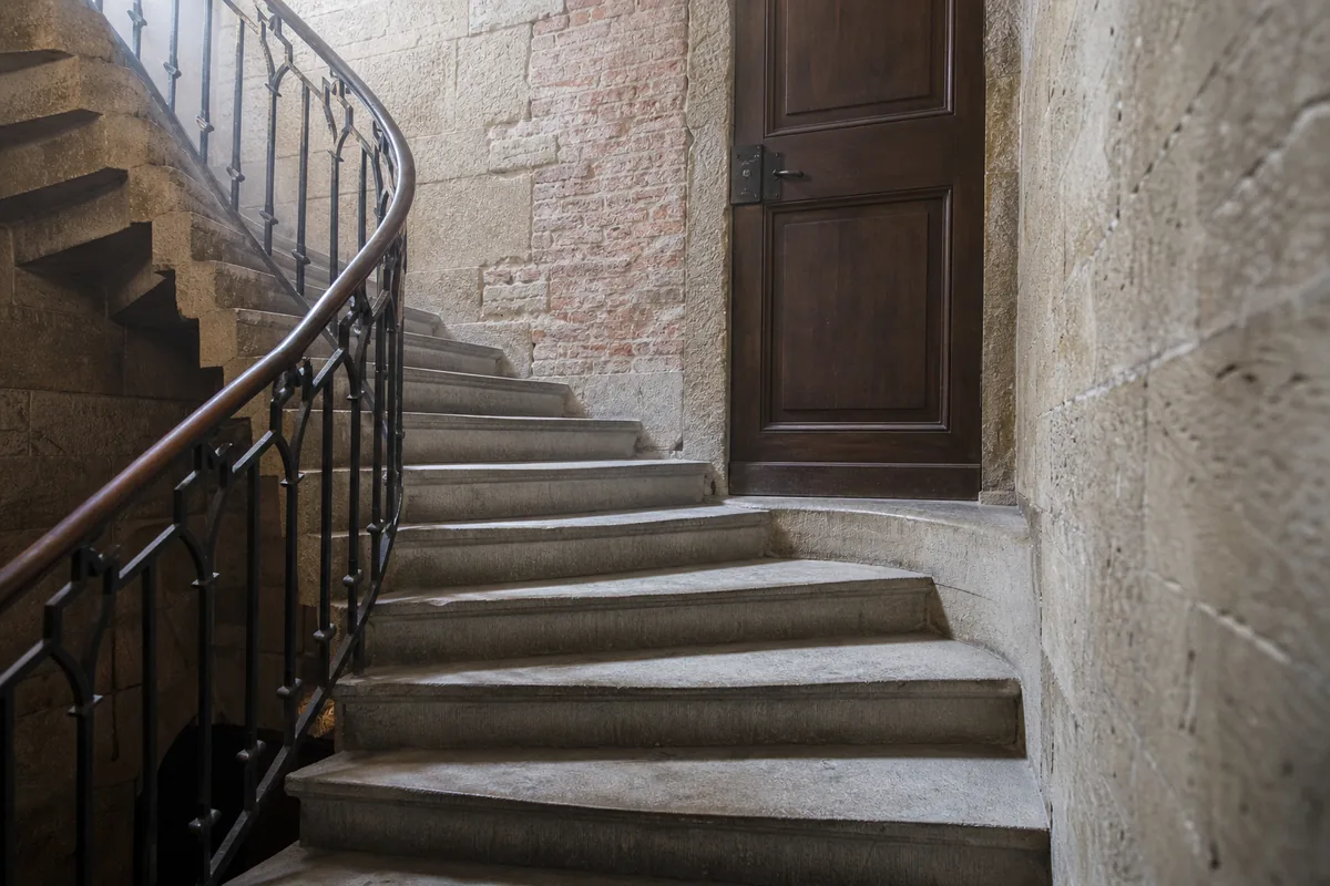 Porte palière en bois ancien dans une montée de pierre de molasse claire