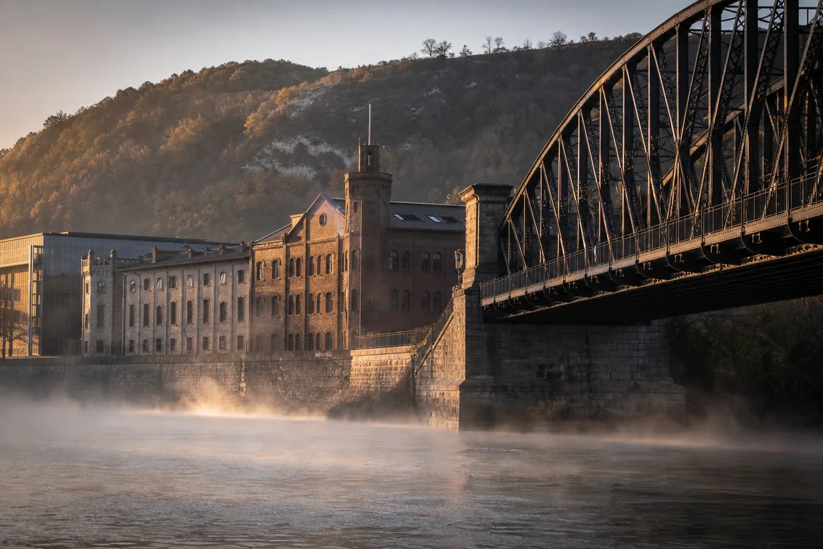 Berges du Rhône à Givors au petit matin, façades de brique d’une ancienne usine dans une lumière rasante